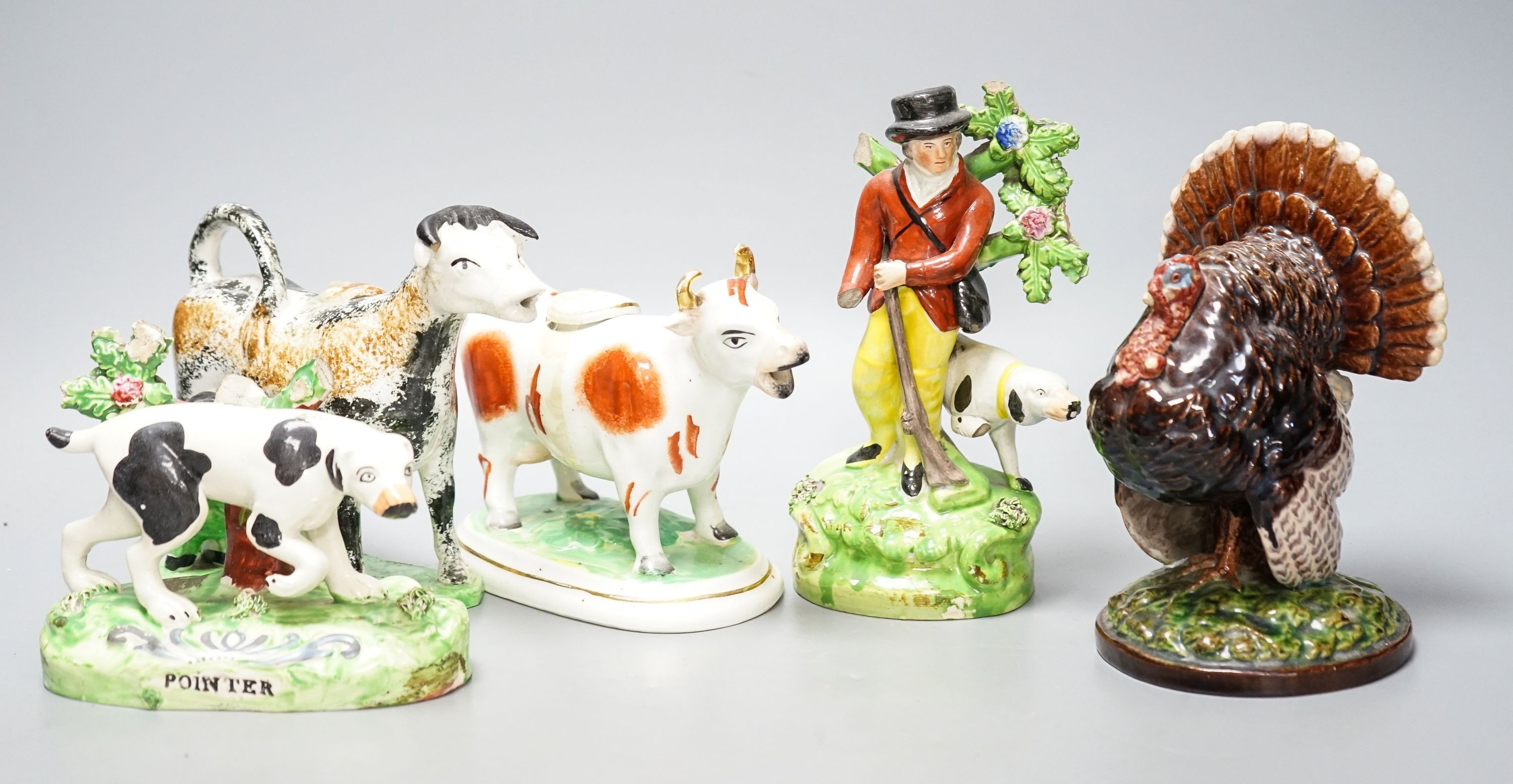 A 19th century 'Milkmaid and cow' creamer with sponged decoration, three other Staffordshire items and a Continental majolica figure of a turkey (5)